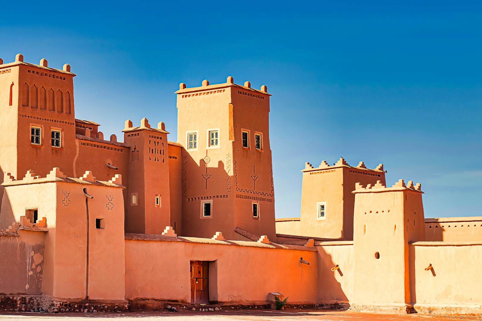 A stunning view of a traditional Moroccan fortress with distinct architectural features against a bright blue sky