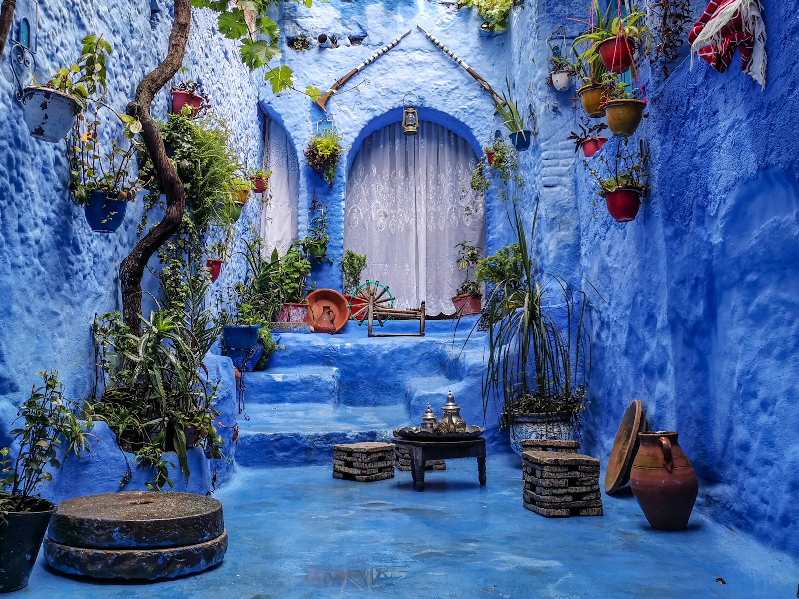 a blua8 days Northern Morocco From Fese alley with potted plants and a bench